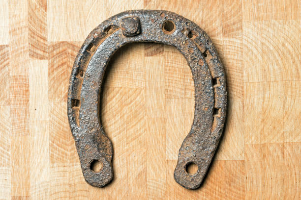 istock Old rusty horseshoe on a wooden background 916575528