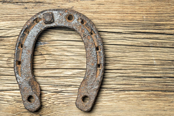 istock Old rusty horseshoe on a old wooden background 916579826