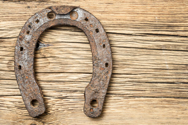 istock Old rusty horseshoe on a old wooden background 916582688
