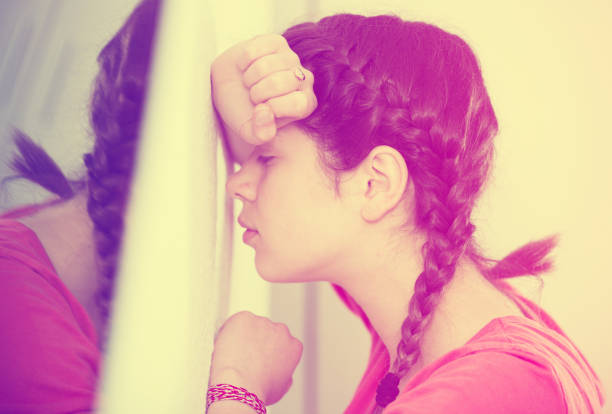 Sad young female teenager spending day alone at home