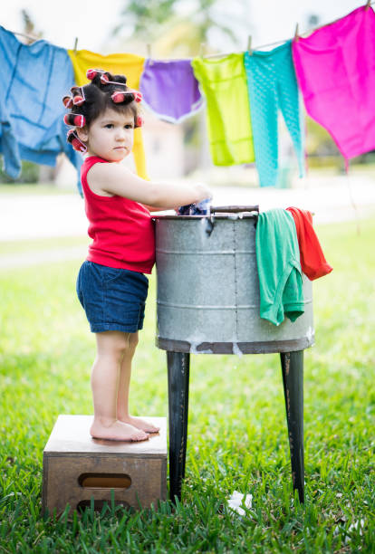 istock Girl doing the laundry old style 916588088