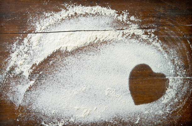 istock Baking background with heart shape from flour on the wooden table 916594378
