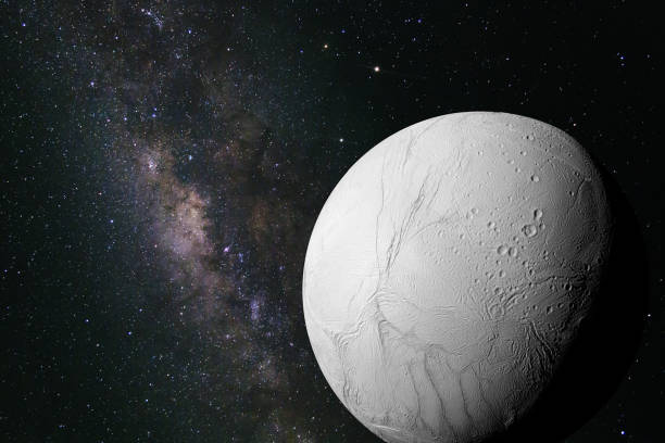 Enceladus, moon of the planet Saturn in front of the galaxy stock photo