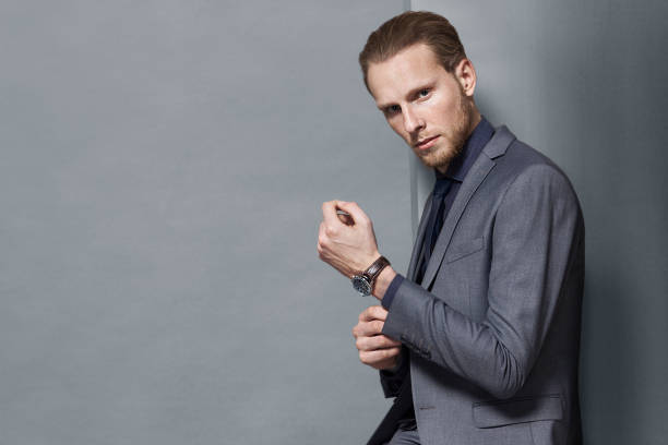 istock man bearded in gray suit posing standing gray studio background 916599574