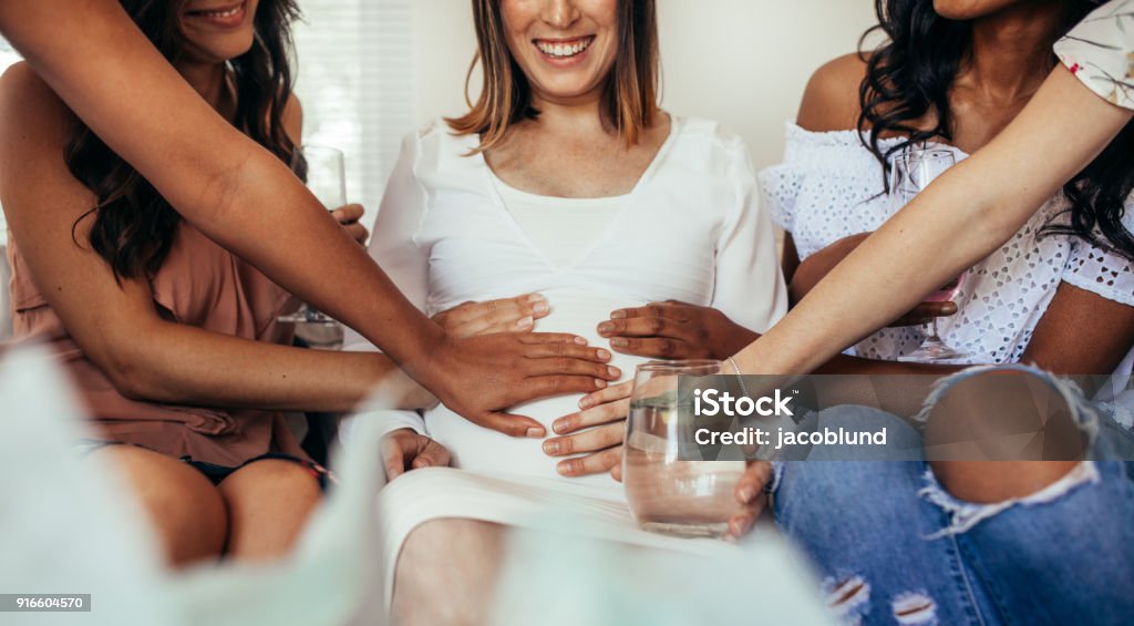 Amigos que comparten el cuidado y la positividad para el embarazo - Foto de stock de Embarazada libre de derechos