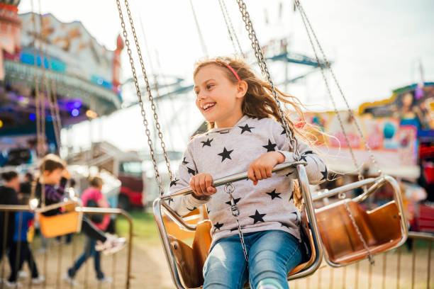 istock Riding on the Swings at the Fairground 916605826