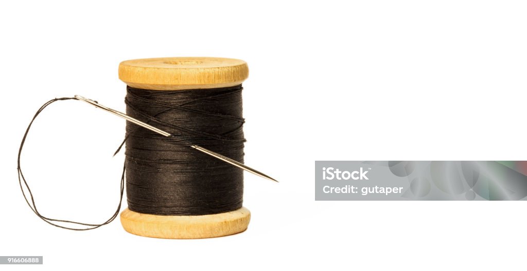 Sewing Needle With Black Thread Stuck In Wooden Spool With Black