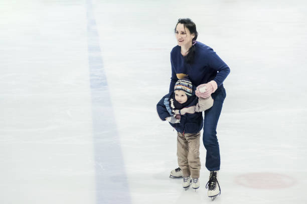 istock happy little boy and his mother learning ice-skating 916613540