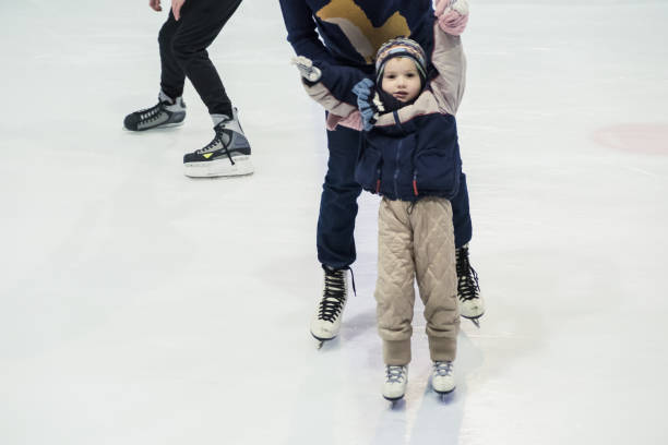 istock happy little boy and his mother learning ice-skating 916613544