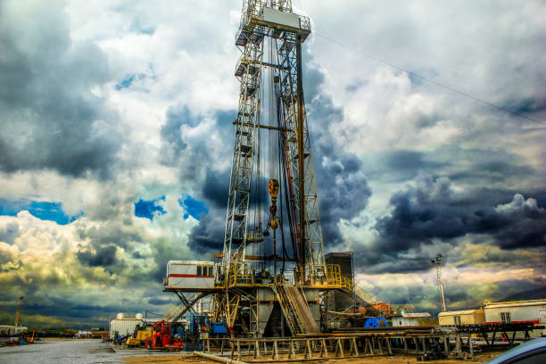 perforazione sulla piattaforma del pozzo geotermico e attrezzature in una giornata nuvolosa - drilling rig oilfield drill drilling foto e immagini stock