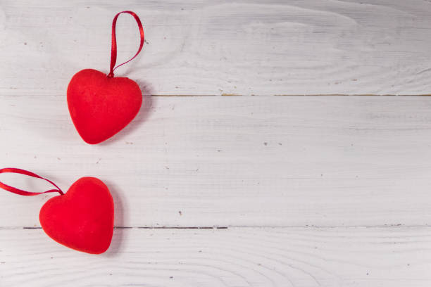 istock Two red hearts on white wooden background 916630110
