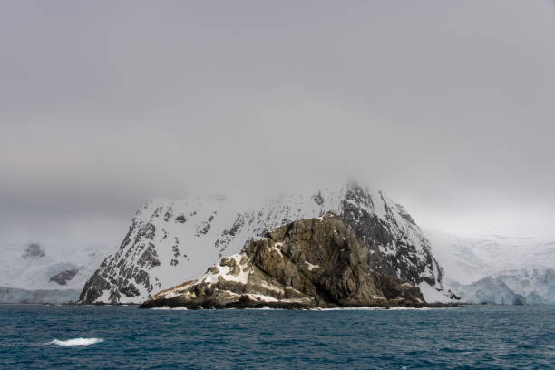 Rock with snow in sea