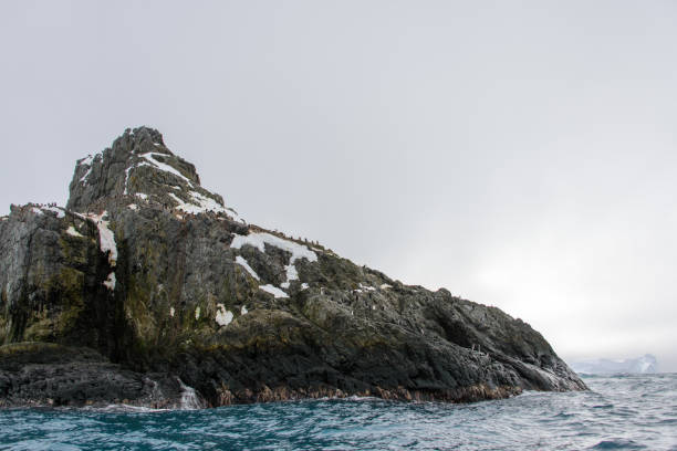 istock Rock with snow in sea 916636306