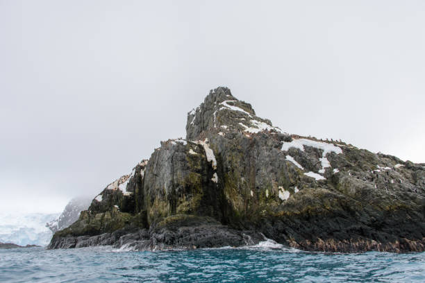 istock Rock with snow in sea 916636544