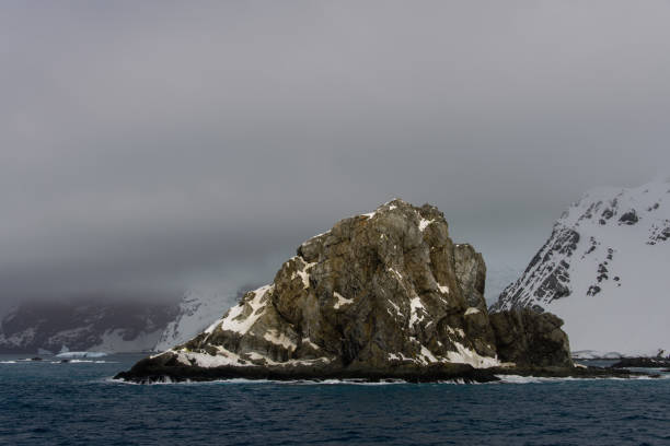 istock Rock with snow in sea 916636656