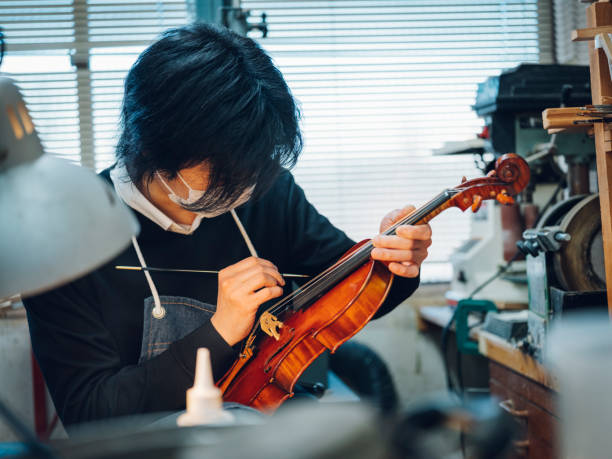 liutaio per violino antico - workshop old fashioned old instrument maker foto e immagini stock