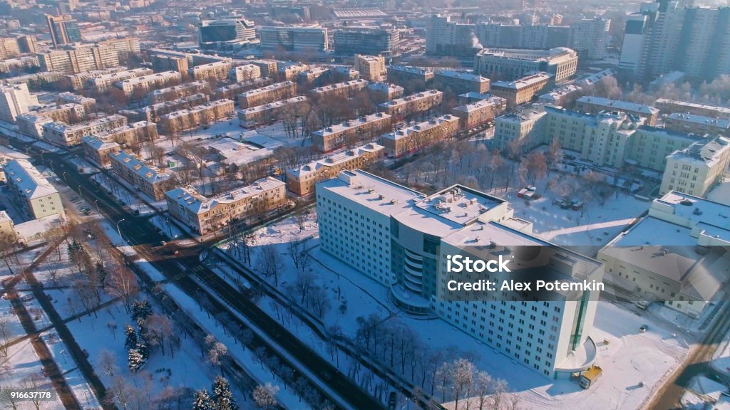 The aerial panoramic view on the winter city covered by the snow in the bright cold sunny day. Orbit camera motion. The aerial panoramic view on the residential district of the winter city covered by the snow in the bright cold sunny day.  Minsk, Belarus, Eastern Europe Minsk Stock Photo