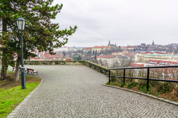 A stone-paved pedestrian path runs along the edge of The Prague vyšehrad fortress wall.