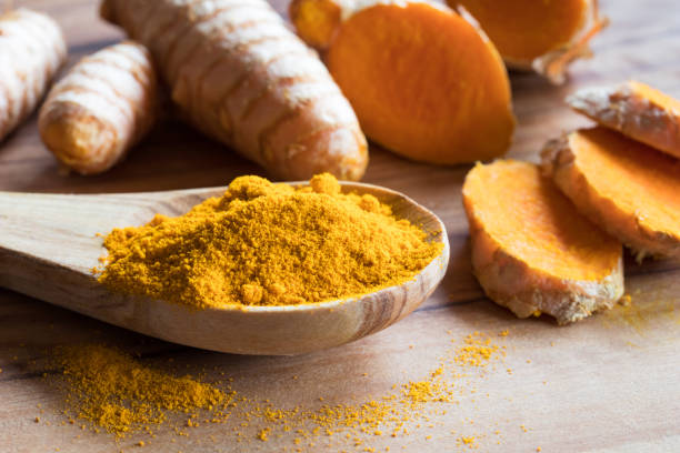 polvere di curcuma con radice di curcuma fresca - curcumin foto e immagini stock