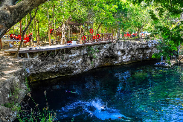 istock Man jumps in lake. Cenote Mexico 916661094