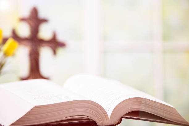 istock Open Bible, Christian cross, with tulips for Easter. 916664676