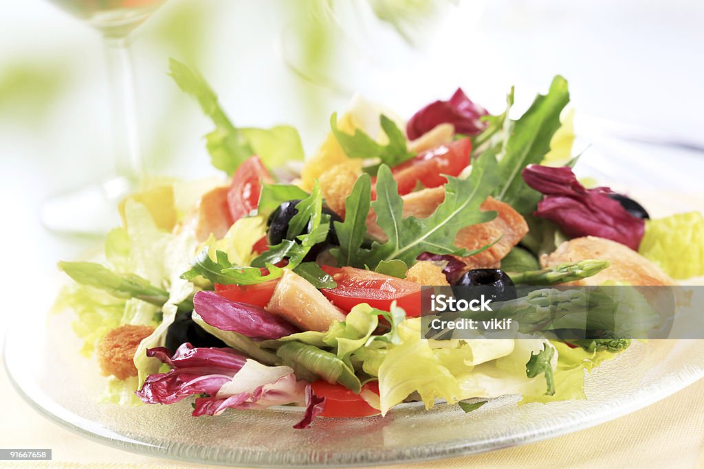 A fresh chicken and vegetable salad on a clear plate Fresh chicken and vegetable salad - detail Arugula Stock Photo