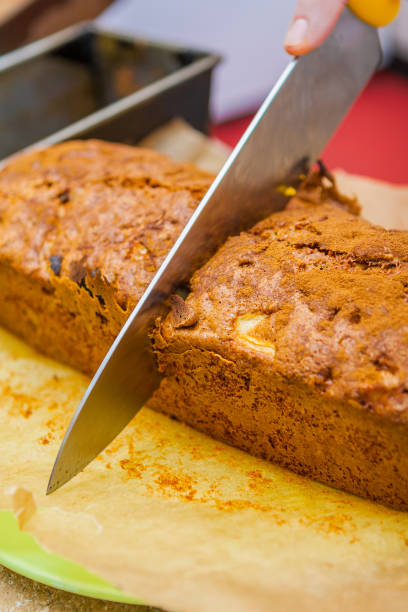 istock Chef's Knife Cutting Loaf of Apple Bread 916678954
