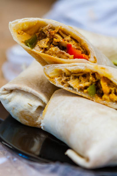 istock Close-up of Shredded Chicken and Vegetable Burritos Cut Open 916679596