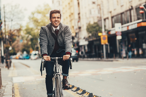 Elegant man riding a bicycle in the city.