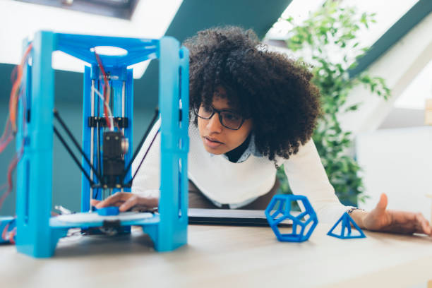 Female Programmer Working in Her Office Female Programmer Working in Her Office. Standing by the desk and coding for 3D printer. 3d printing stock pictures, royalty-free photos & images