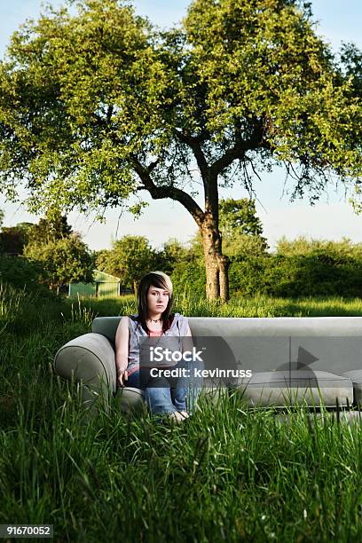 Chica Joven Sentado En Un Sofá En La Sala De Estar Al Aire Libre Foto de stock y más banco de imágenes de Campo - Tierra cultivada