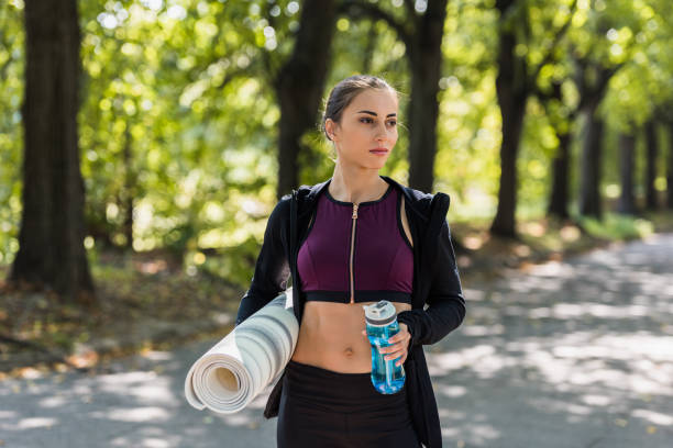 istock woman with yoga mat and water 916701632