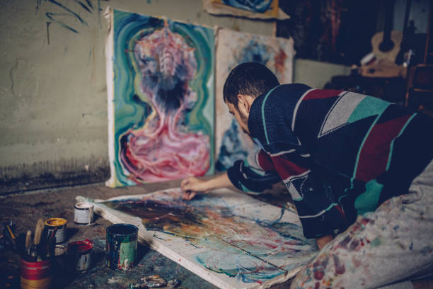 istock Artist-painter working on painting in studio 916709774
