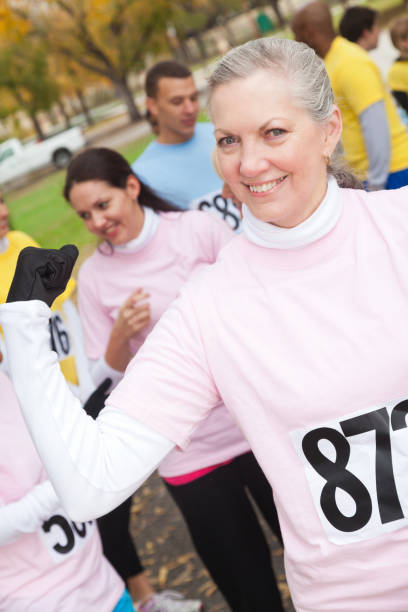 istock Active senior woman flexes muscles during charity walk 916727454
