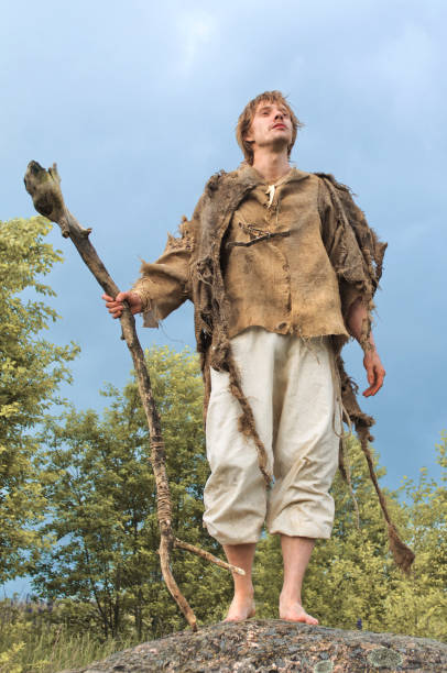 istock guy in a burlap suit and a wooden staff 916741020