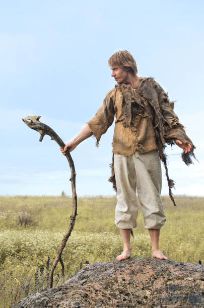 istock guy in a burlap suit and a wooden staff 916741116