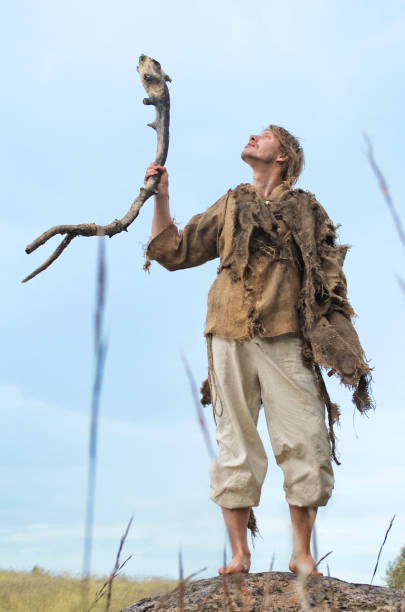 istock guy in a burlap suit and a wooden staff 916741118