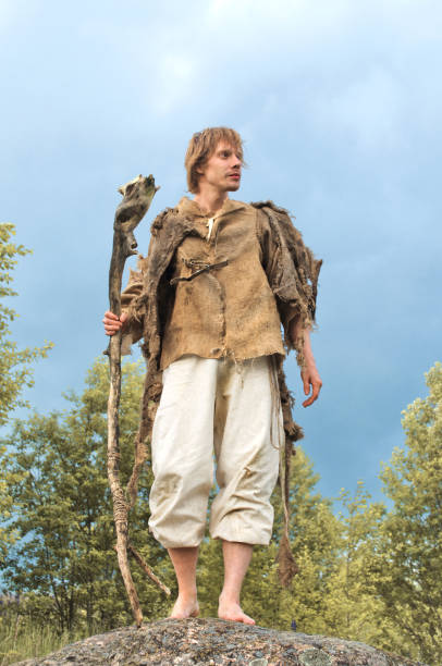 istock guy in a burlap suit and a wooden staff 916741262