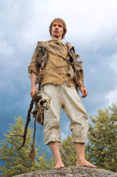 istock guy in a burlap suit and a wooden staff 916743360