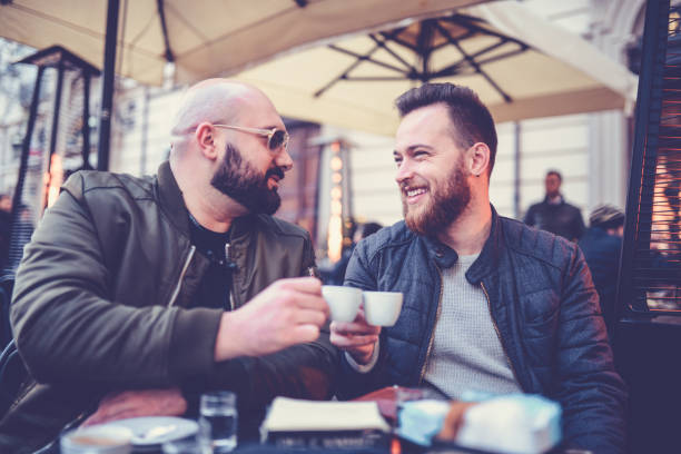 istock Two Smiling Friends Drinking Coffee and Talking in Coffee Shop 916747286