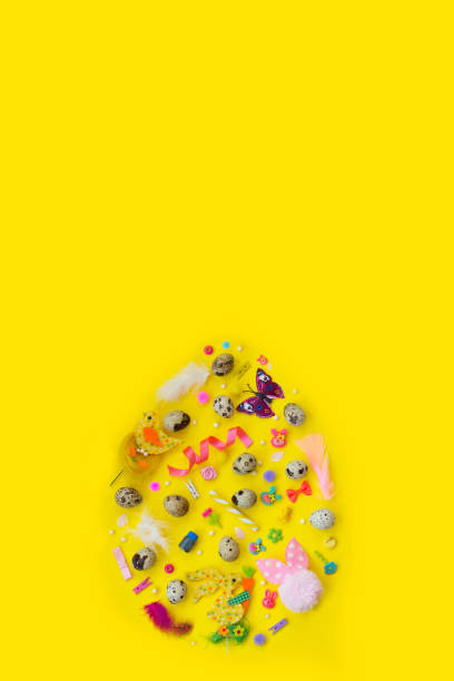 istock Quail eggs and decoration, in egg shape, on yellow background with copy space; easter background 916747314