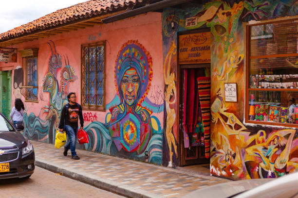 bogotá, colômbia - as pessoas a pé pelas ruas coloridas de la candelaria bairro histórico da cidade de capital - graffiti paintings men walking - fotografias e filmes do acervo