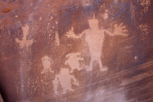 Several petroglyph figures carved into sandstone