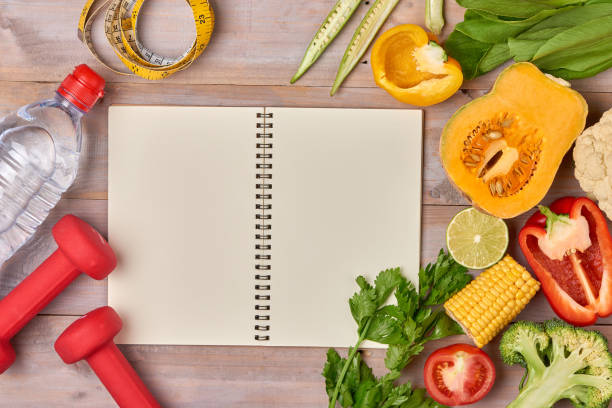 istock Dumbbell, vegetable salad and measuring tape on rustic wooden table. 916769488