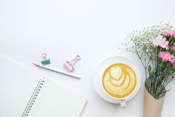 istock Home office desk table with notepad,flower bouquet,computer keyboard on white background.Flat lay.feminine concepts design.minimalist 916773274