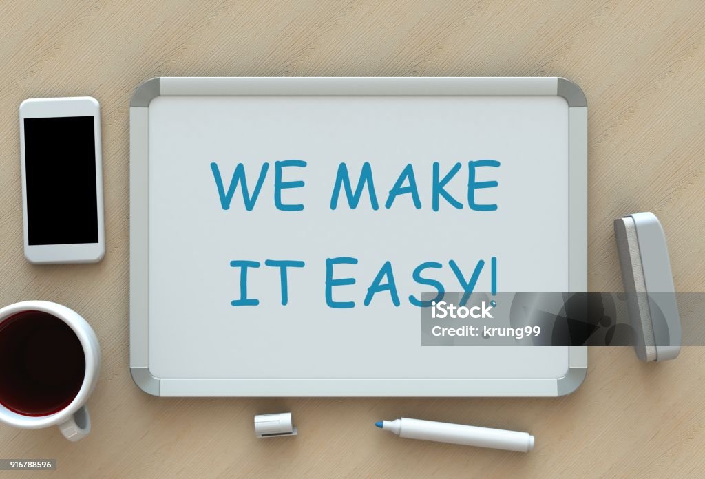 WE MAKE IT EASY!, message on whiteboard, smart phone and coffee on table Effortless Stock Photo