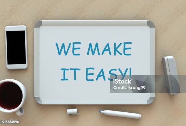 We Make It Easy Message On Whiteboard Smart Phone And Coffee On Table Stock Photo - Download Image Now