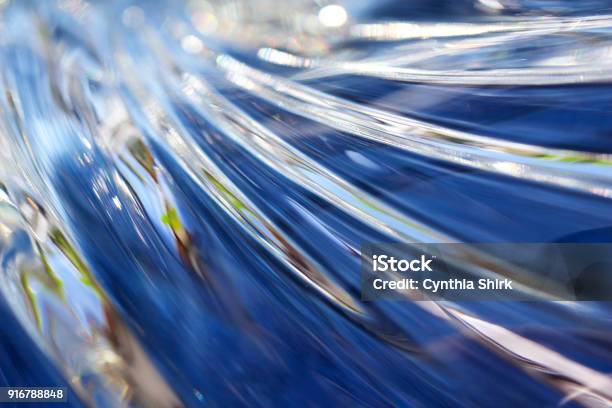 Close Up Of Beautiful Wavy Surfaced Lead Crystal Glass Reflecting Bright Blue Color Stock Photo - Download Image Now