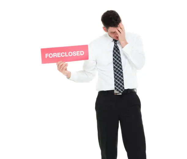 Photo of Waist up businessman holding foreclosed sign