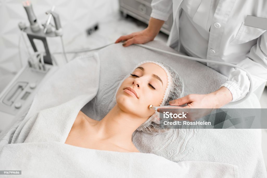 Woman during the facial treatment procedure Young woman during the facial treatment procedure in the cosmetology office Healthcare And Medicine Stock Photo